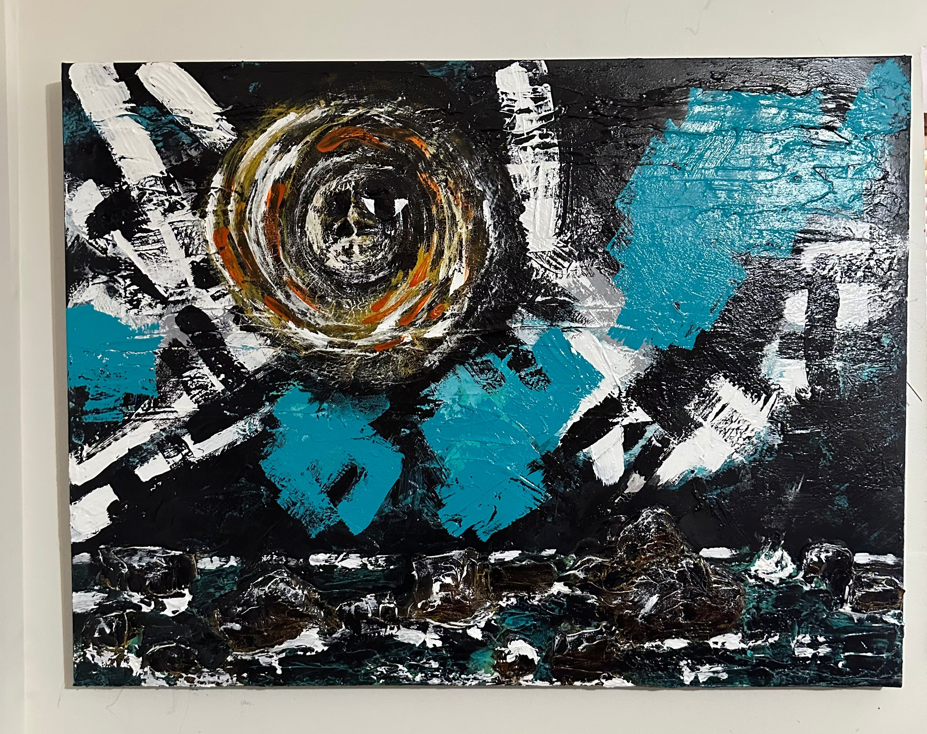 Abstract painting with blue, black, and white colors on a white wall.